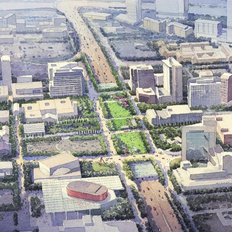 Aerial view of a mixed-use development area with roadways, commercial buildings, and surrounding land parcels.